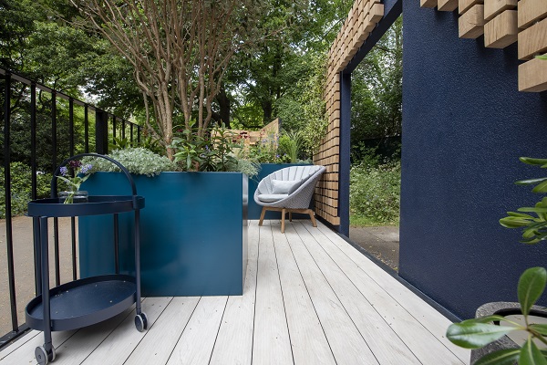 Polar DesignBoard composite decks RHS Chelsea 2023 balcony garden with blue square planters, chair in background.