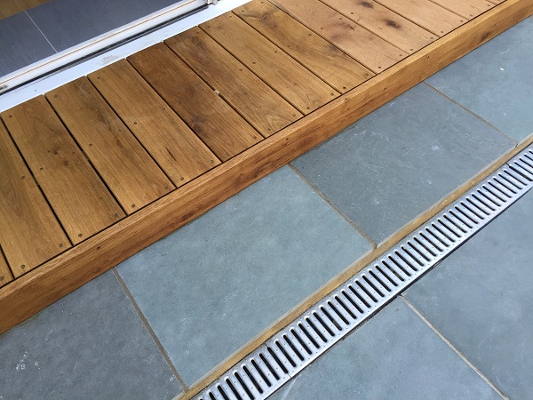 Kota blue limestone laid next to wooden step with stainless steel channel drain.