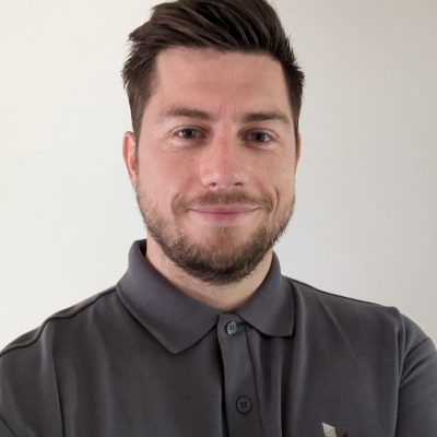 Man with beard and moutache, smiling.