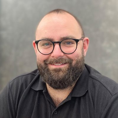 Bald man with beard and moustache and glasses, smiling