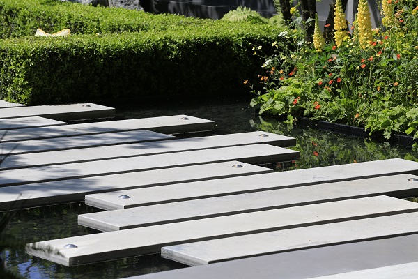 75mm thick Jura Grey plank paving lies in staggered pattern across pond in LG Eco-City Garden, RHS Chelsea Flower Show 2018.