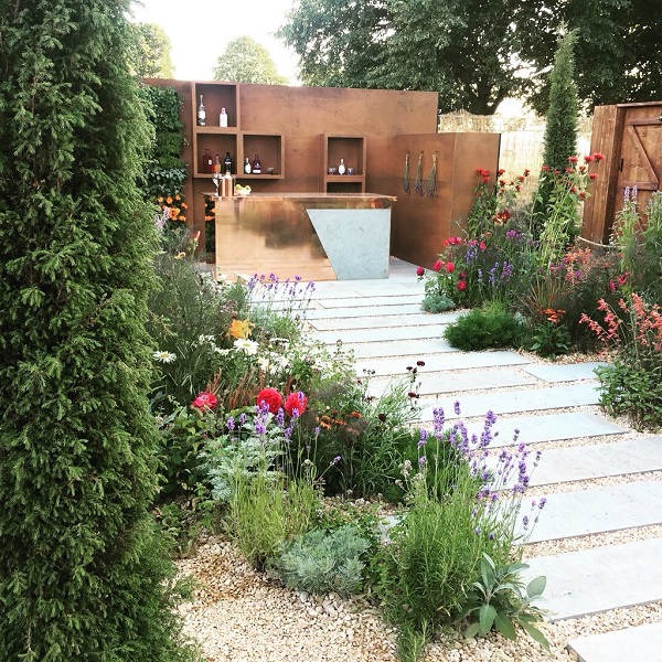 Plank paving path between planting to bar partly faced with Grey Yorkstone panel and copper.