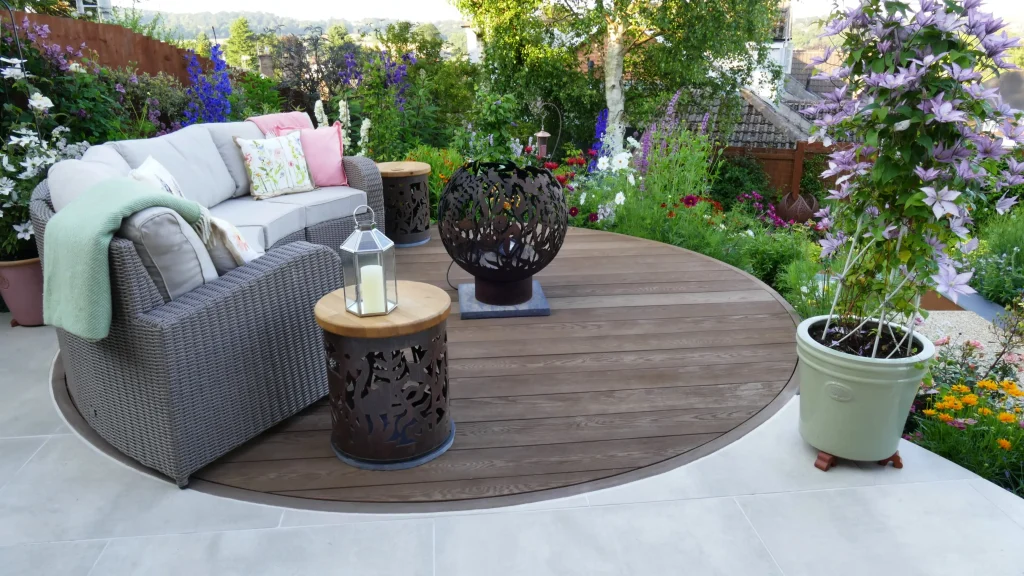 Round Millboard Coppered Oak decking circle with Cream porcelain paving cut to fit edge.