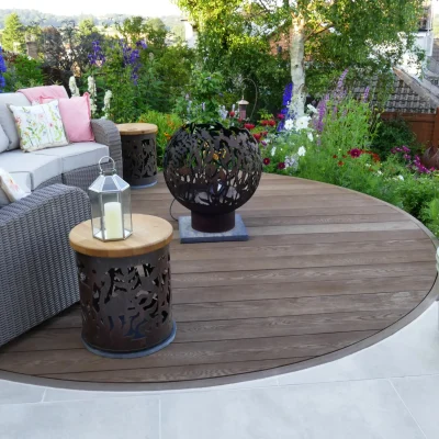 Round Millboard Coppered Oak decking circle with Cream porcelain paving cut to fit edge.