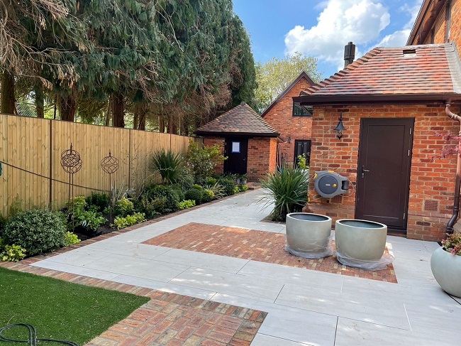 Faro porcelain patio on corner of brick house with soldier course edging of Cotswold clay pavers