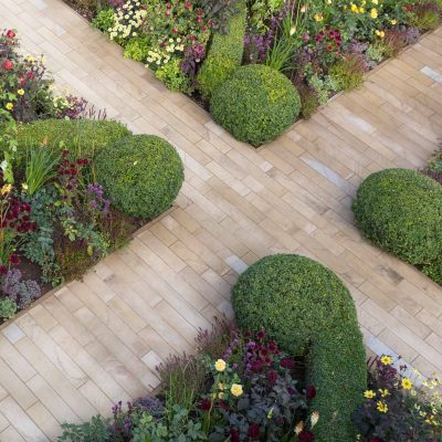 2 paths cross, dividing 4 beds with topiary and low hedges creating planting triangles