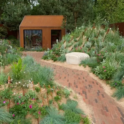 Clay paver path runs getween planted sandy banks to a bothy, Hospitalfield Arts Garden, RHS Chelsea 2025