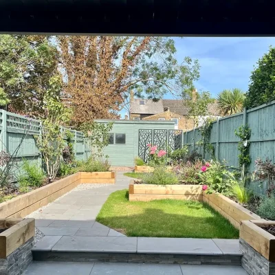 Graphite Grey limestone paving with step up to path down side of lawn in fenced garden