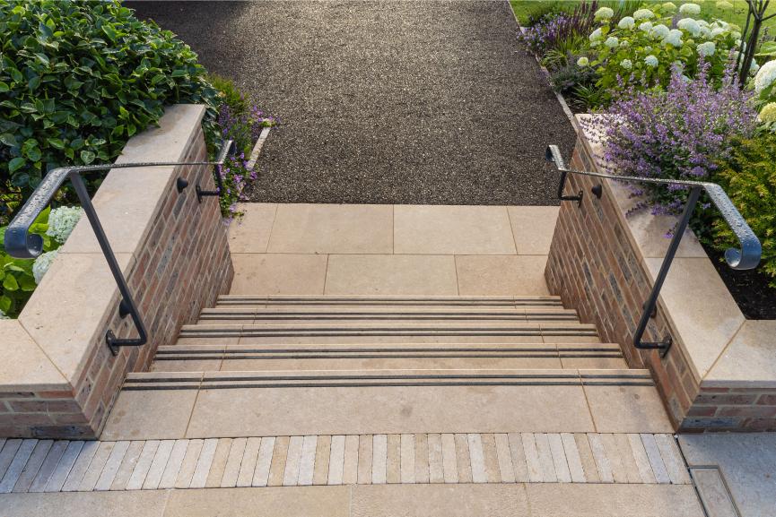 Flight of 5 Egyptian Beige steps edged with carborundum strips descend between flank walls