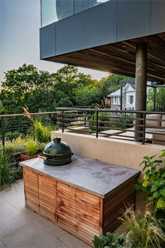 Barbecue sits on counter with Florence Grey porcelain splashback. 