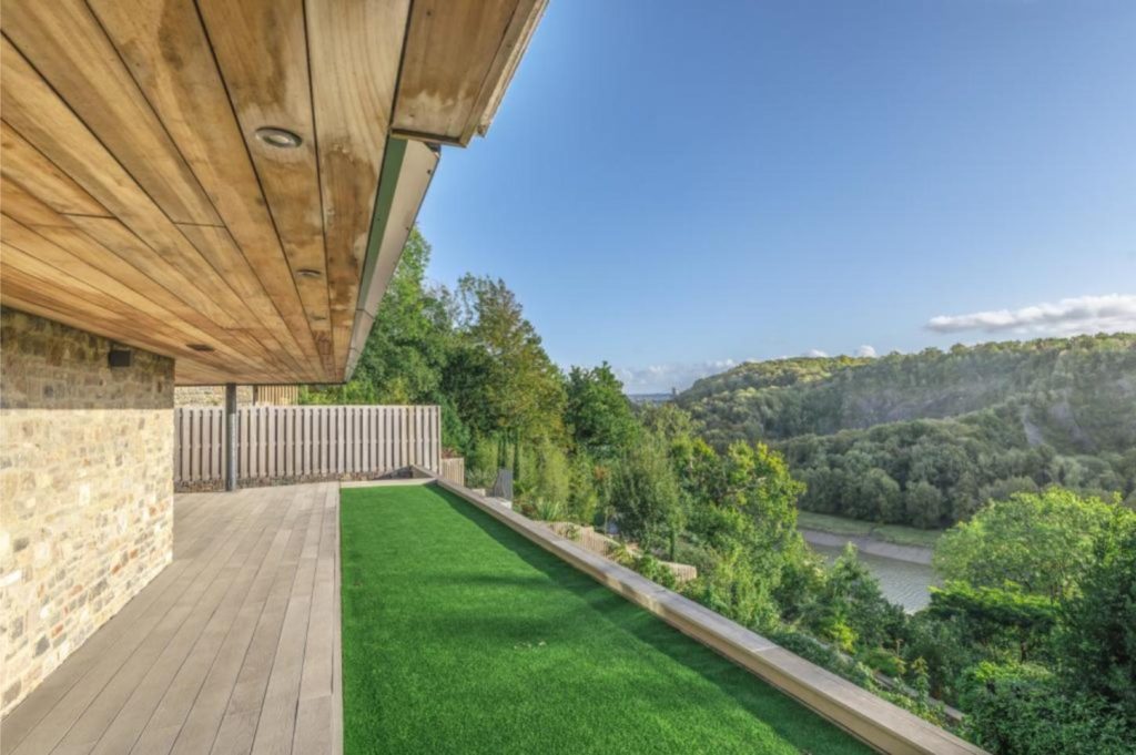 View across valley from long patio of decking and artificial grass