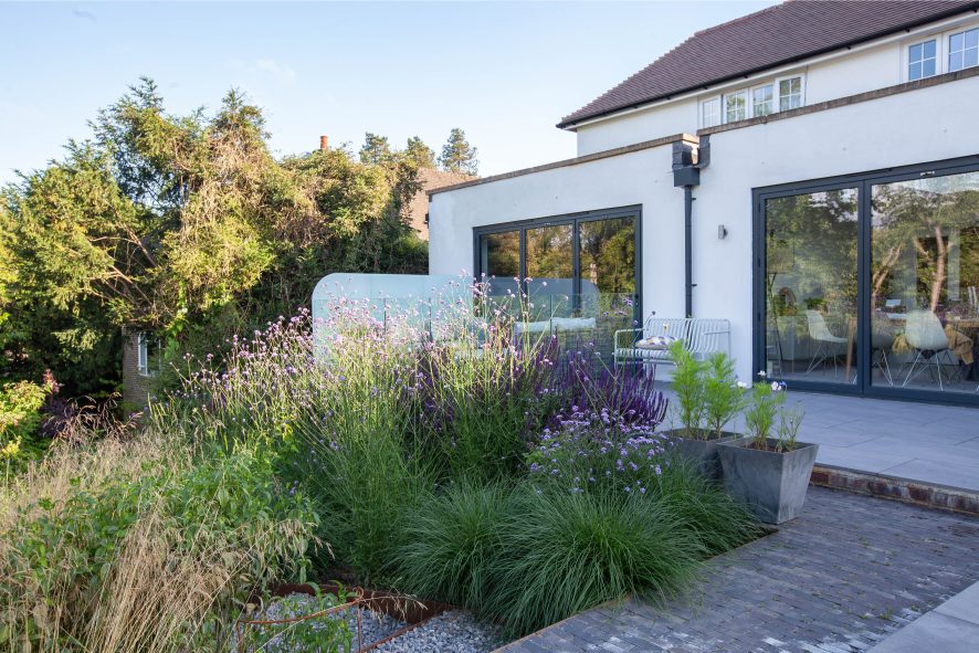 Moderna clay paving between porcelain patio and airy planting with gravel steps