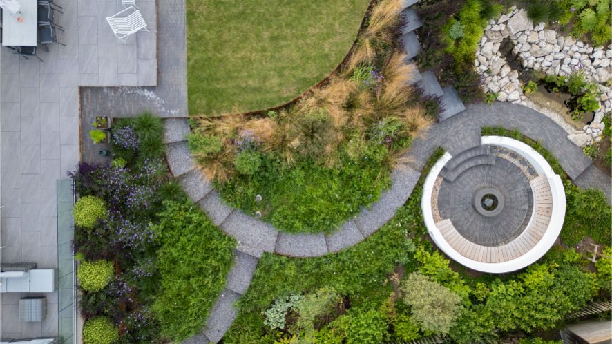 Overhead view of garden with curved paths and lawn.