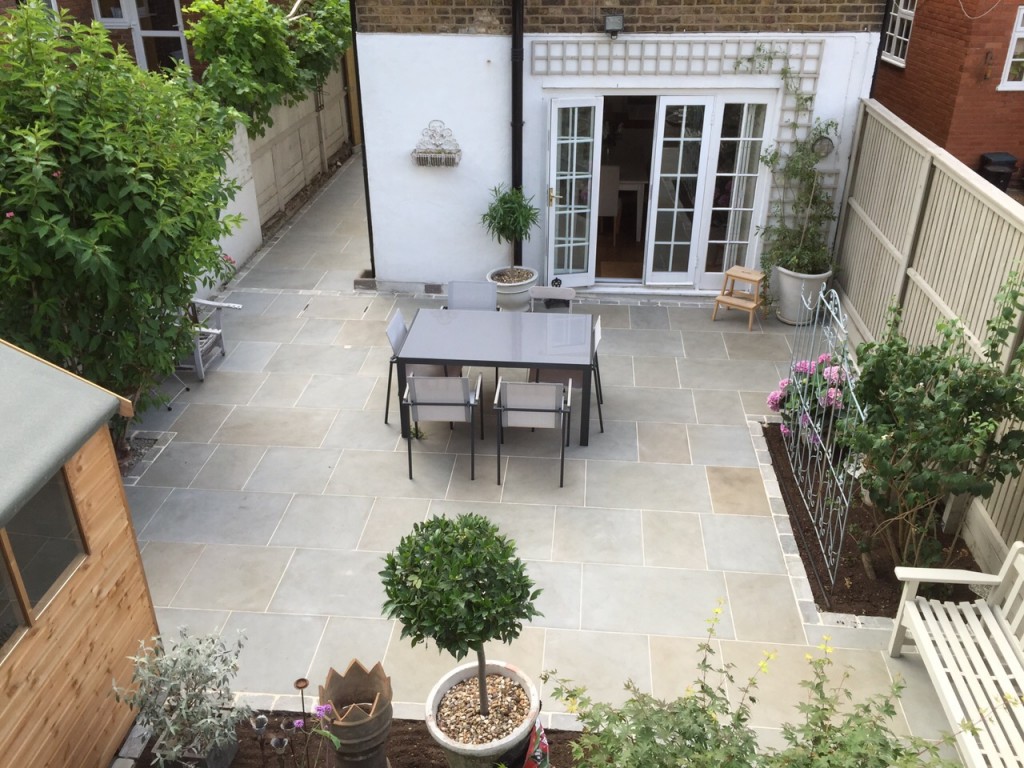 Heah sawn sandstone paving slabs for a small garden, laid by Jardin Landscapes, to create a courtyard. 