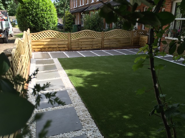 Trendy Black Porcelain with gravel and artificial grass in front garden by Aye Gardening.